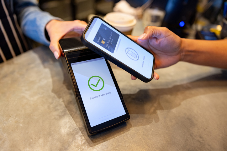Close-up on a customer making a mobile payment at a cafe